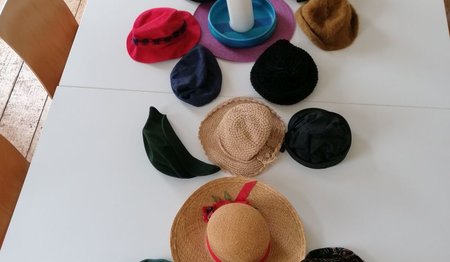verschiedene Hüte liegen auf dem Tisch